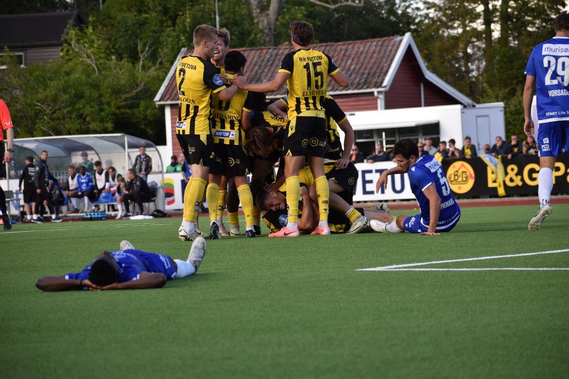 Ingvald Sandvik Halgunset omfavnes av lagkameratene etter overtidsscoring hjemme mot Start. Ingvald sørget for at EIK vant 3-2 etter en av mange snuoperasjoner under Kjell Andrés ledelse.
Foto: Kjell Åvendal.